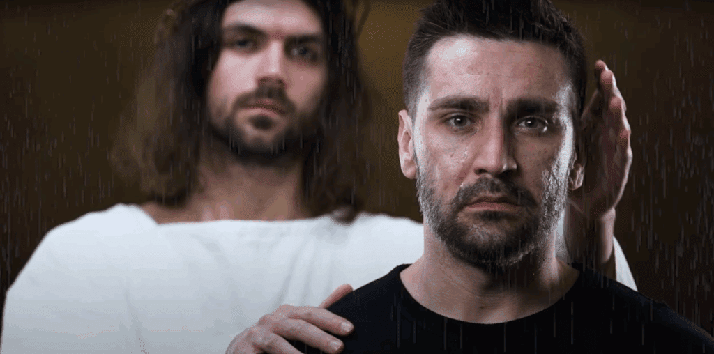 Jesus standing behind man with his hand on his shoulder.
